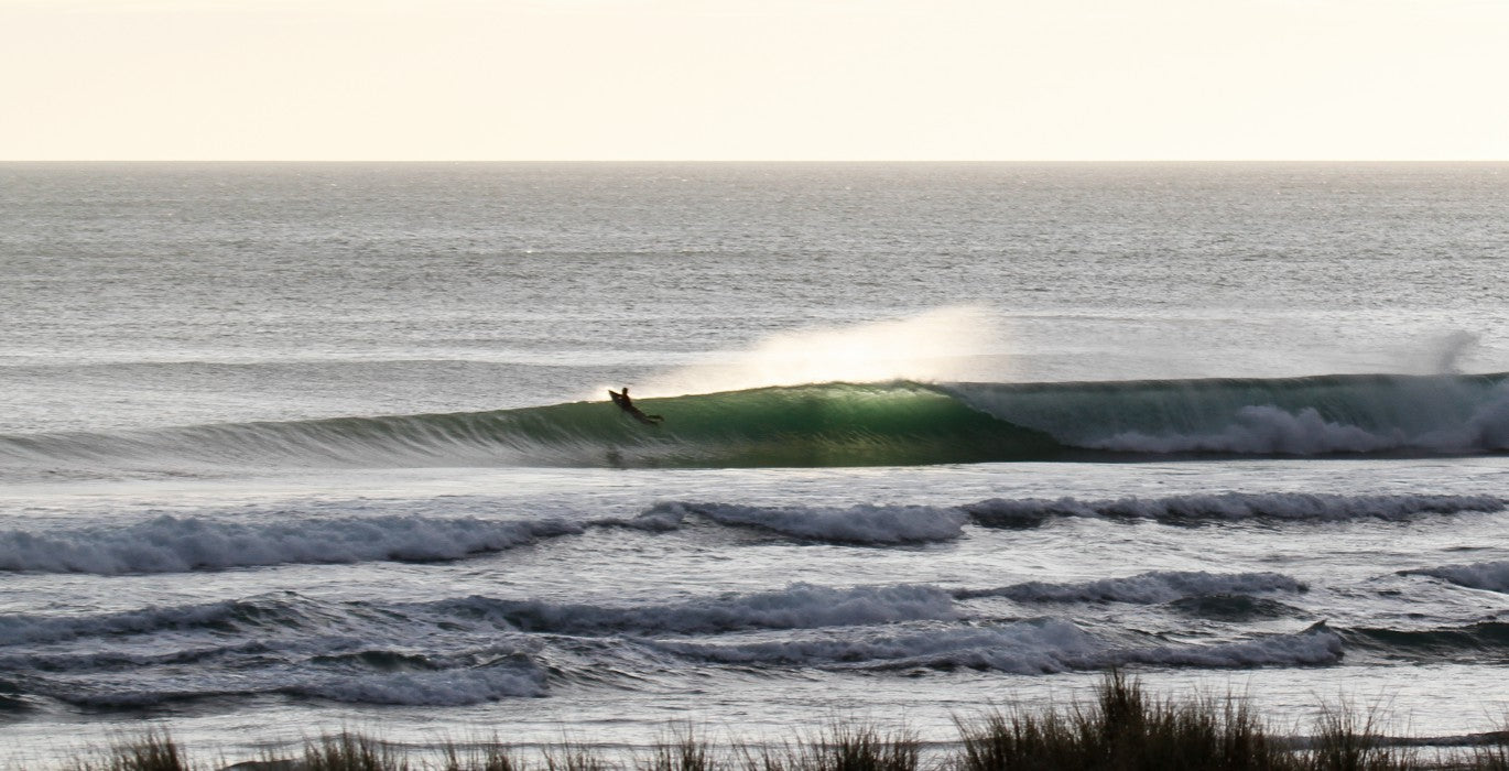 Surfer paddling over a nice clean wave